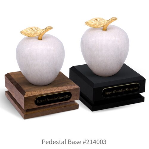 black and a brown walnut pedestal bases with black brass plates and white marble apples