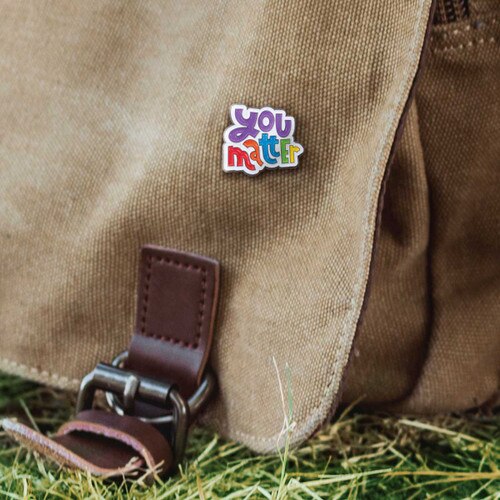 you matter lapel pin on a canvas bag